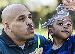 Father and daughter blowing bubbles
