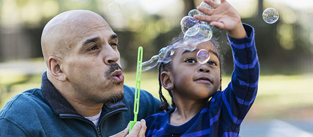 Father and daughter blowing bubbles